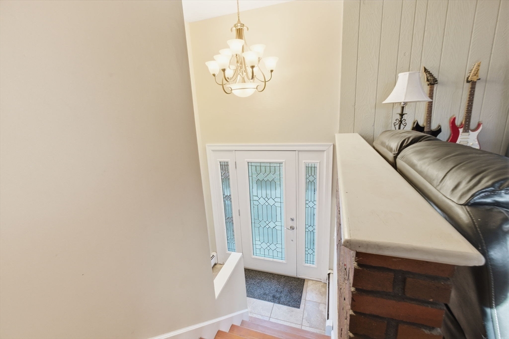 78 Dunstable Road Westford, MA 01886 - Photo 17 of 27 a view of a bedroom with wooden floor and a chandelier