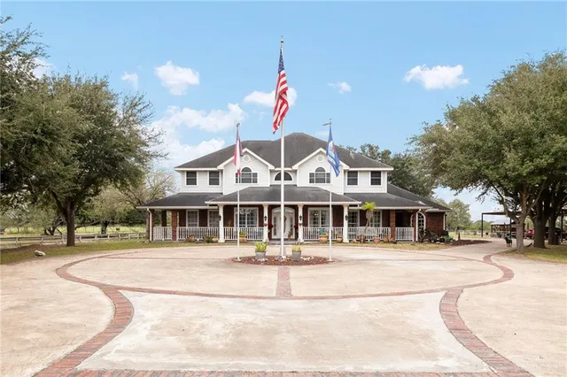 a front view of a building with lot of trees and entertaining space