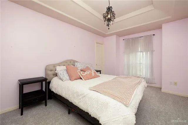 a bedroom with a bed and a chandelier
