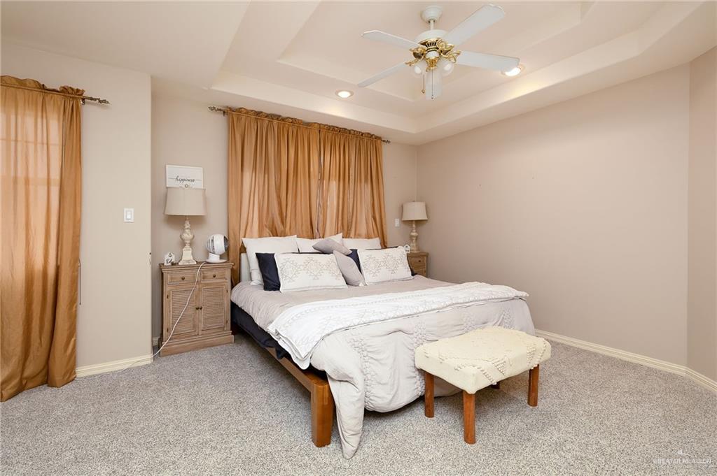23725 North Val Verde Road Edinburg, TX 78542 - Photo 31 of 38 Bedroom featuring carpet, a tray ceiling, and a ceiling fan