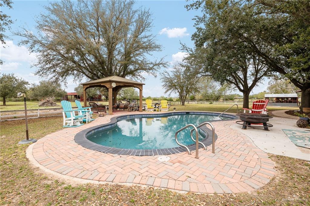 23725 North Val Verde Road Edinburg, TX 78542 - Photo 5 of 38 Outdoor pool featuring a patio area, a gazebo, and a fire pit