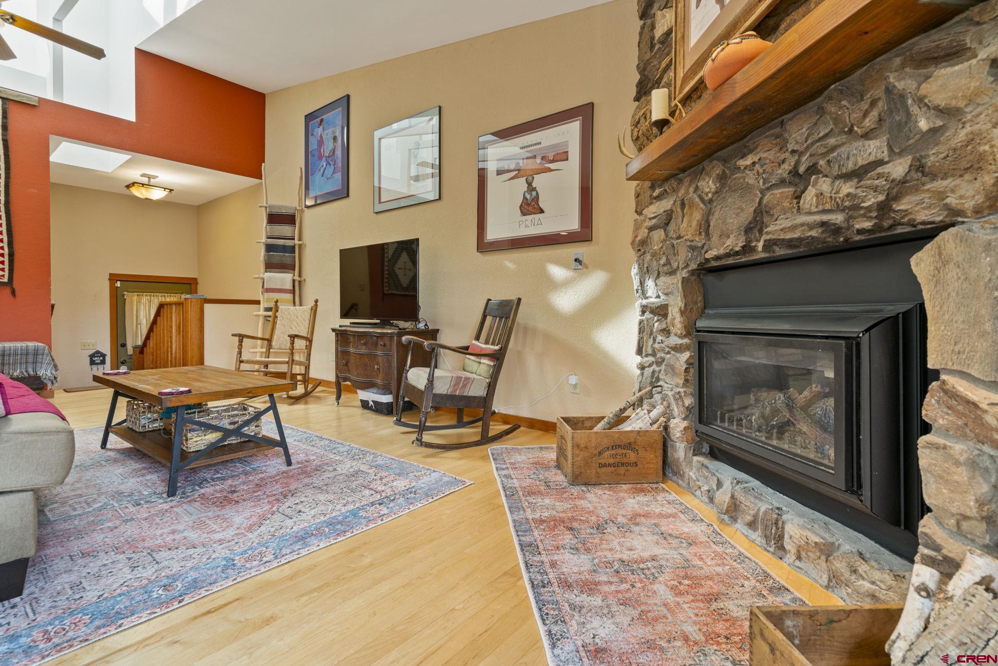 333 Pine Ridge Loop, Unit 4 Durango, CO 81301 - Photo 4 of 33 a living room with furniture a flat screen tv and a fireplace