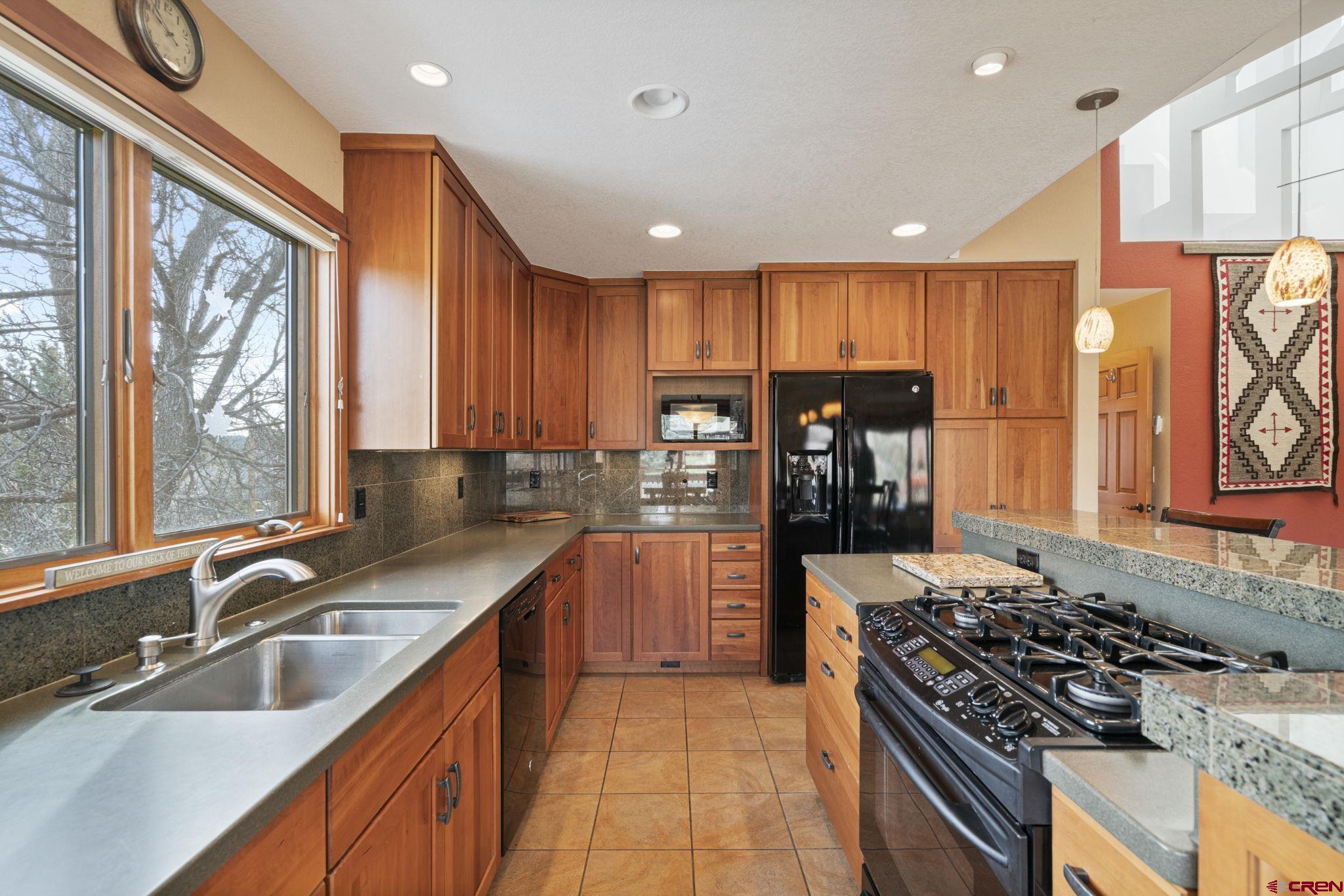 333 Pine Ridge Loop, Unit 4 Durango, CO 81301 - Photo 7 of 33 a kitchen with stainless steel appliances granite countertop a sink stove refrigerator and cabinets