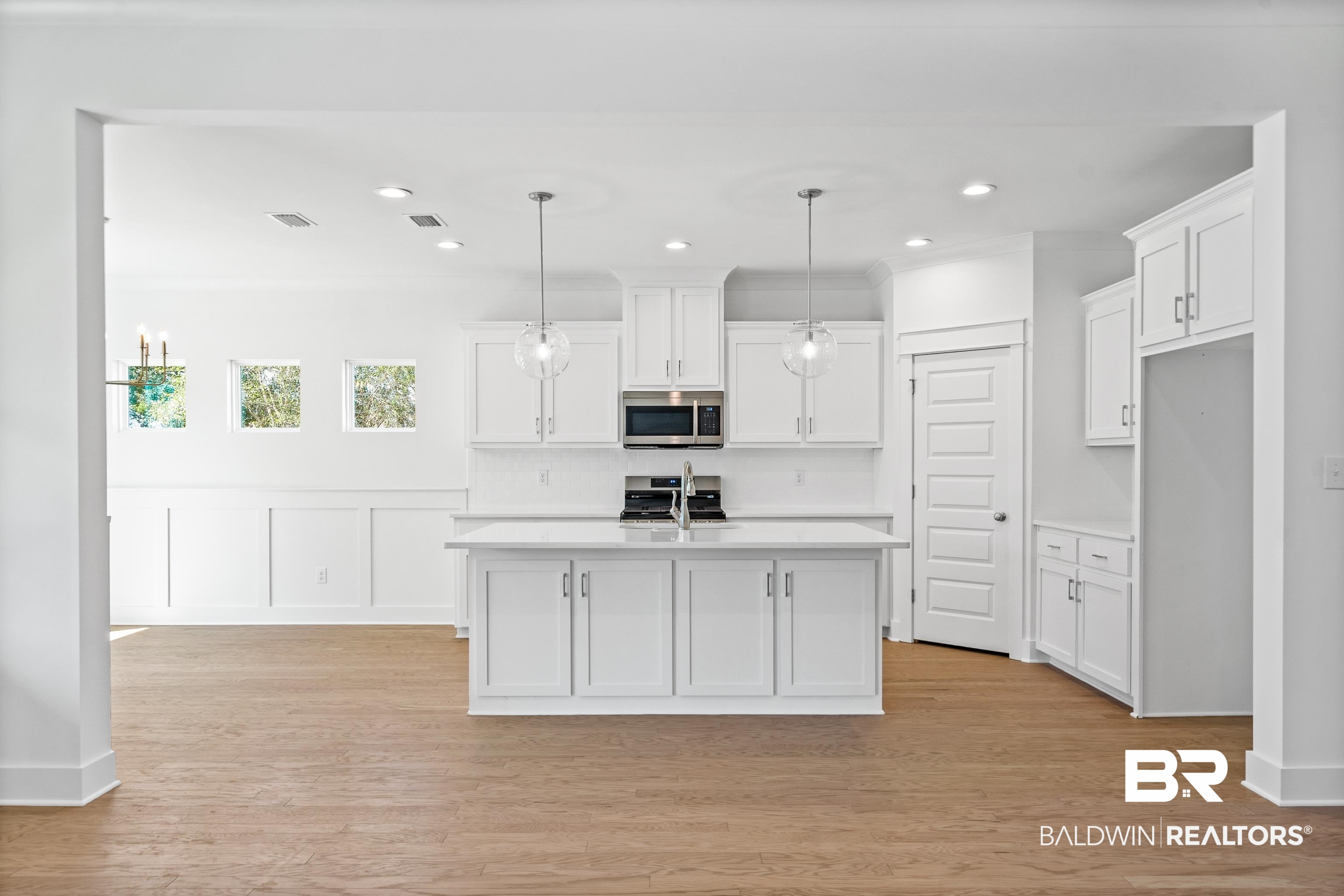 25927 Capra Court Daphne, AL 36526 - Photo 7 of 37 Kitchen with hanging light fixtures, white cabinetry, and stainless steel appliances