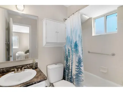 a bedroom with a bed window and a wall painting