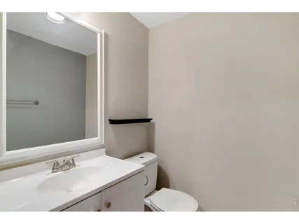 a view of an empty room with wooden floor and windows