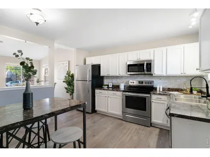 a dining room with furniture and potted plants