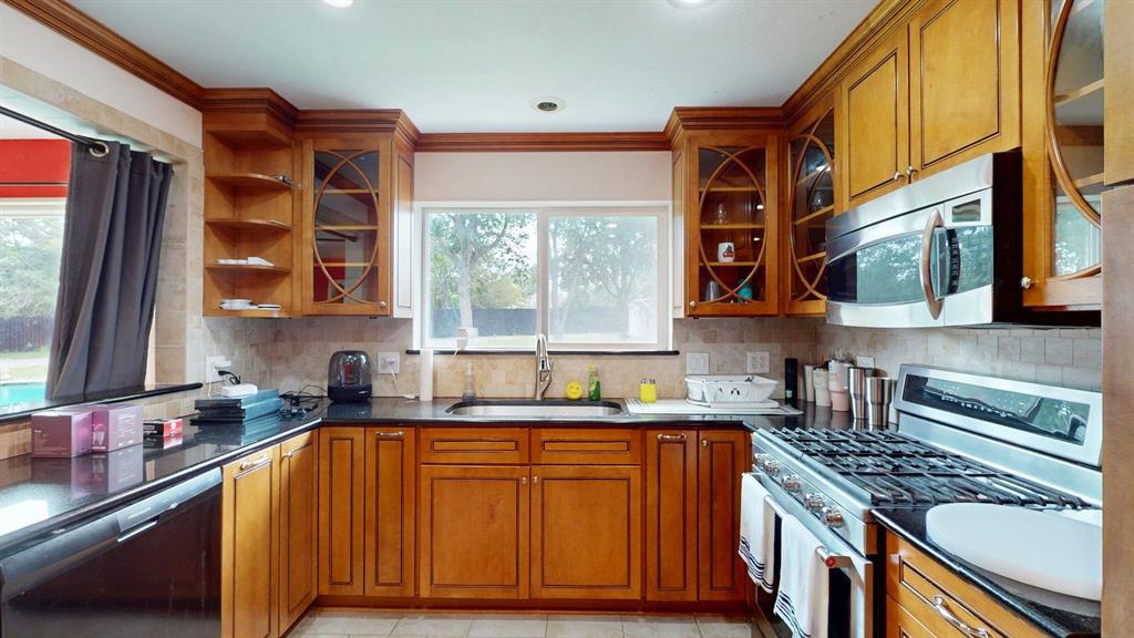 1206 South Clark Road Duncanville, TX 75137 - Photo 11 of 38 a kitchen with stainless steel appliances granite countertop a stove a sink dishwasher and cabinets with wooden floor
