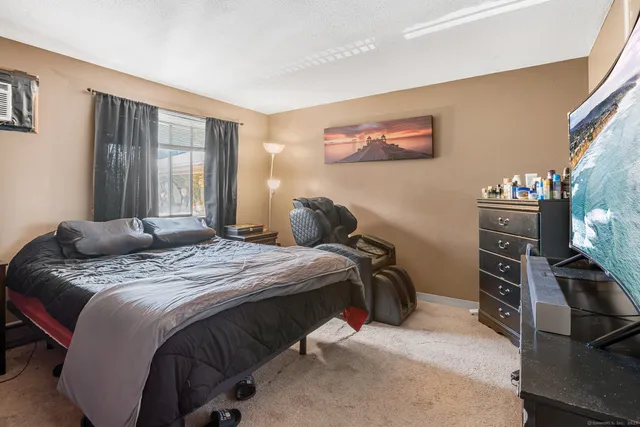 a bedroom with a bed and a flat tv screen