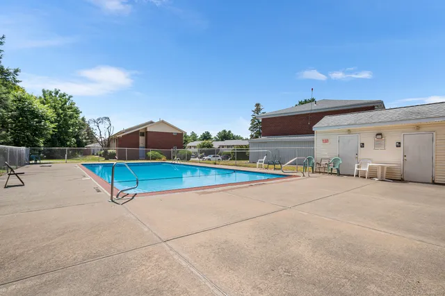 a view of a tennis ground with a table and chairs under an umbrella