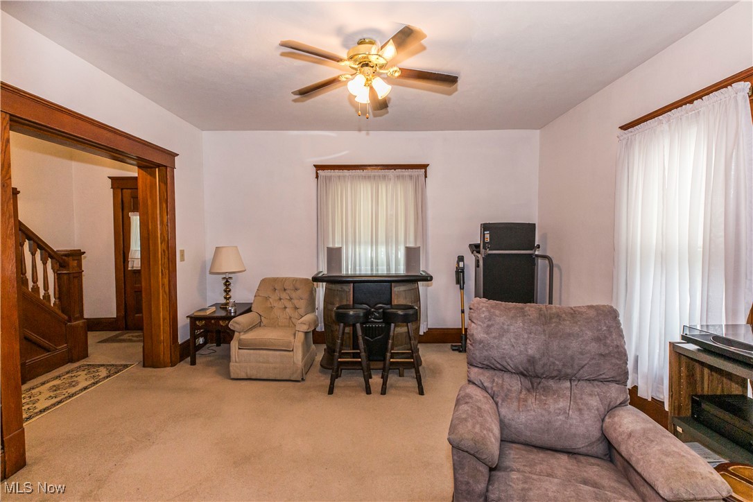 749 Amherst Road Northeast Massillon, OH 44646 - Photo 17 of 41 Living area featuring ceiling fan, carpet floors, and stairway