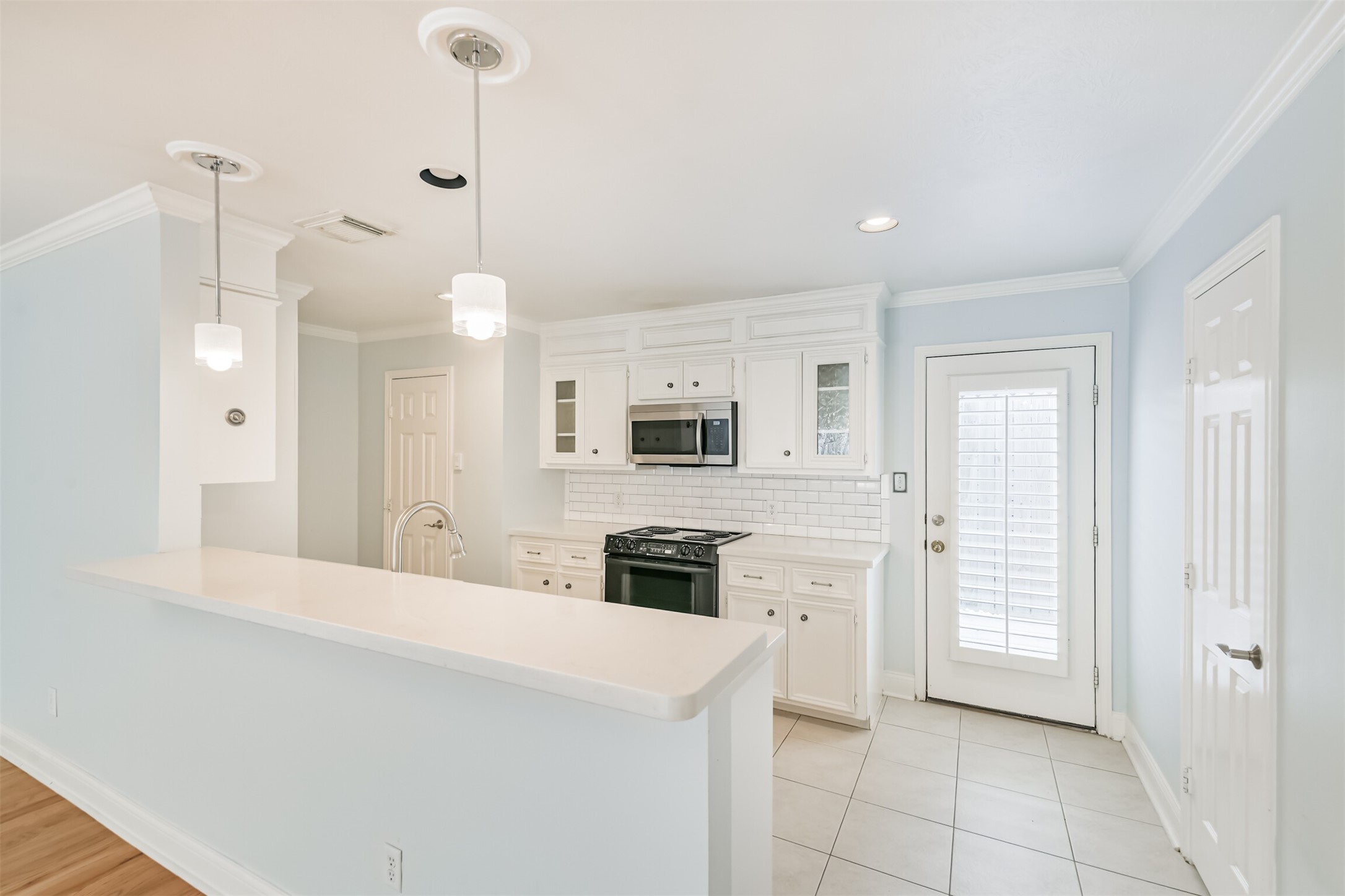 738 Redwing Pl Drive Houston, TX 77009 - Photo 7 of 23 Clean lines with white quartz countertops define this stylish kitchen with direct access to the private outdoor space - perfect for grilling and entertaining.