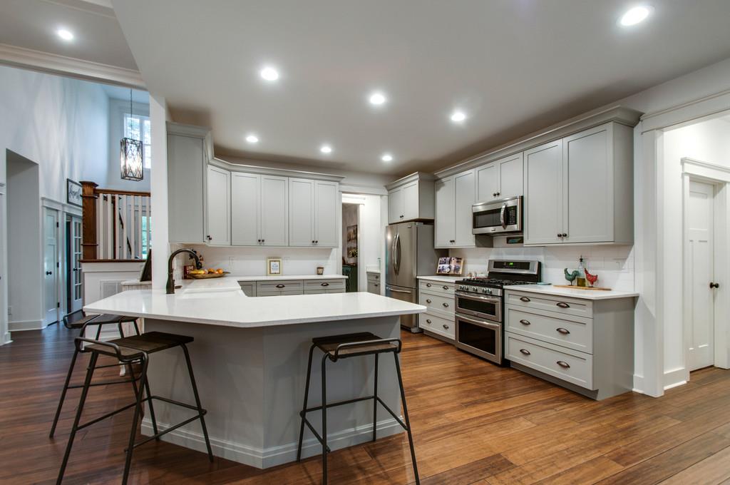 1335 Camp Ravine Road Burns, TN 37029 - Photo 17 of 29 a kitchen with stainless steel appliances kitchen island granite countertop a stove a sink a refrigerator and white cabinets with wooden floor