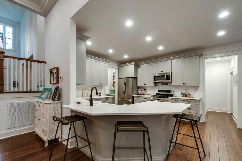 1335 Camp Ravine Road Burns, TN 37029 - Photo 20 of 29 a kitchen with stainless steel appliances kitchen island granite countertop a dining table chairs and a refrigerator