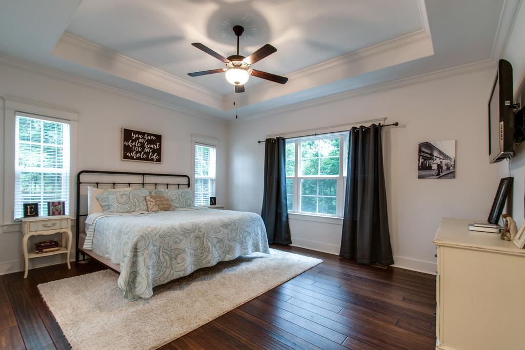 1335 Camp Ravine Road Burns, TN 37029 - Photo 21 of 29 a bedroom with a large bed a flat tv screen and a dresser