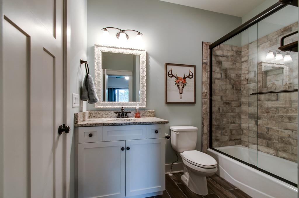 1335 Camp Ravine Road Burns, TN 37029 - Photo 8 of 29 a bathroom with a granite countertop toilet a sink and a mirror