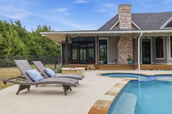a view of a house with swimming pool and sitting area