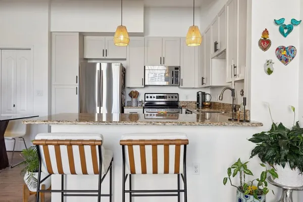 a kitchen with stainless steel appliances granite countertop a refrigerator and a stove