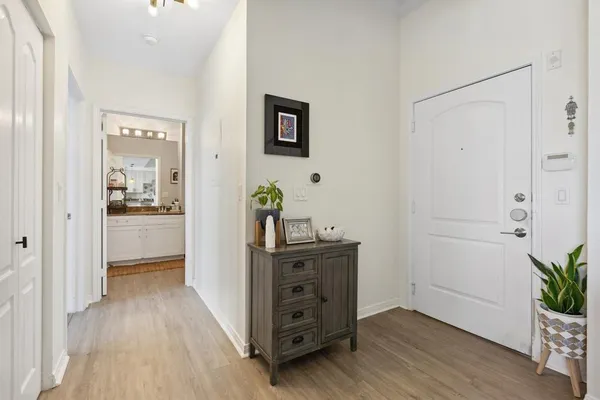 a view of a hallway with wooden floor and furniture