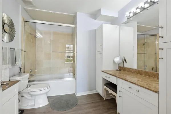 a bathroom with a granite countertop sink toilet and shower