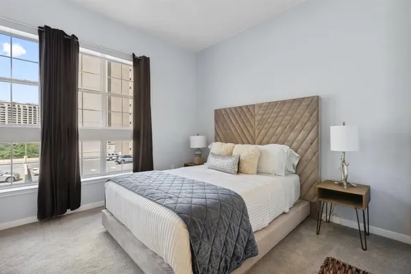 a bedroom with a large bed and a night stand
