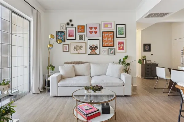 a living room with furniture a rug and a wall painting