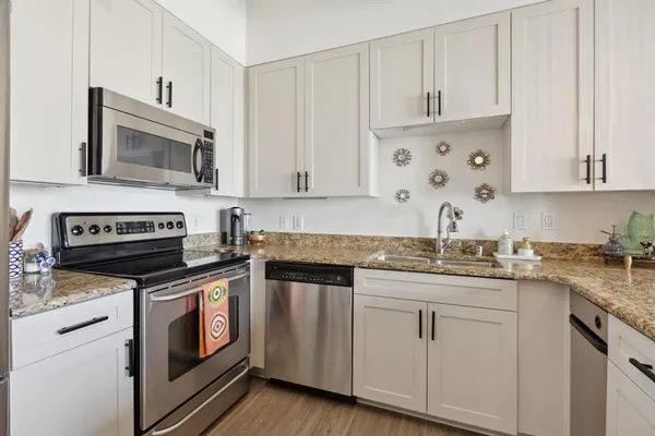 a kitchen with granite countertop cabinets stainless steel appliances and a sink