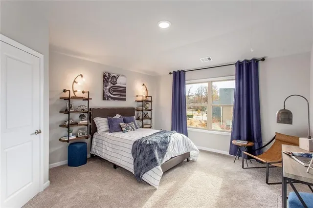 a bedroom with a bed a table and a large window