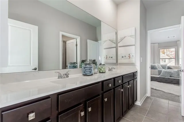 a en suite bathroom with a double vanity sink and a mirror