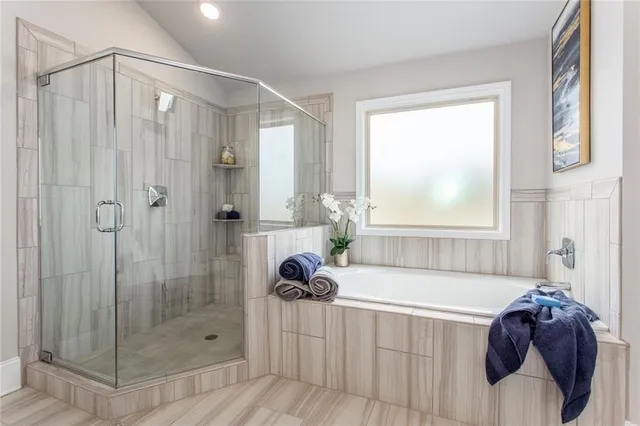 a bathroom with a tub shower and window