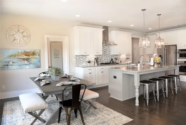 a dining room with wooden floor a chandelier a wooden table and chairs
