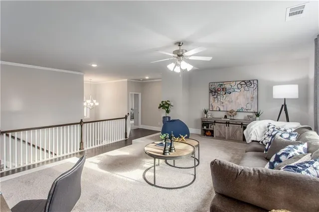 a living room with furniture flowerpot and a chandelier