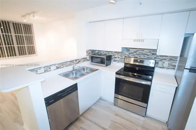 a kitchen with granite countertop a sink stove and refrigerator