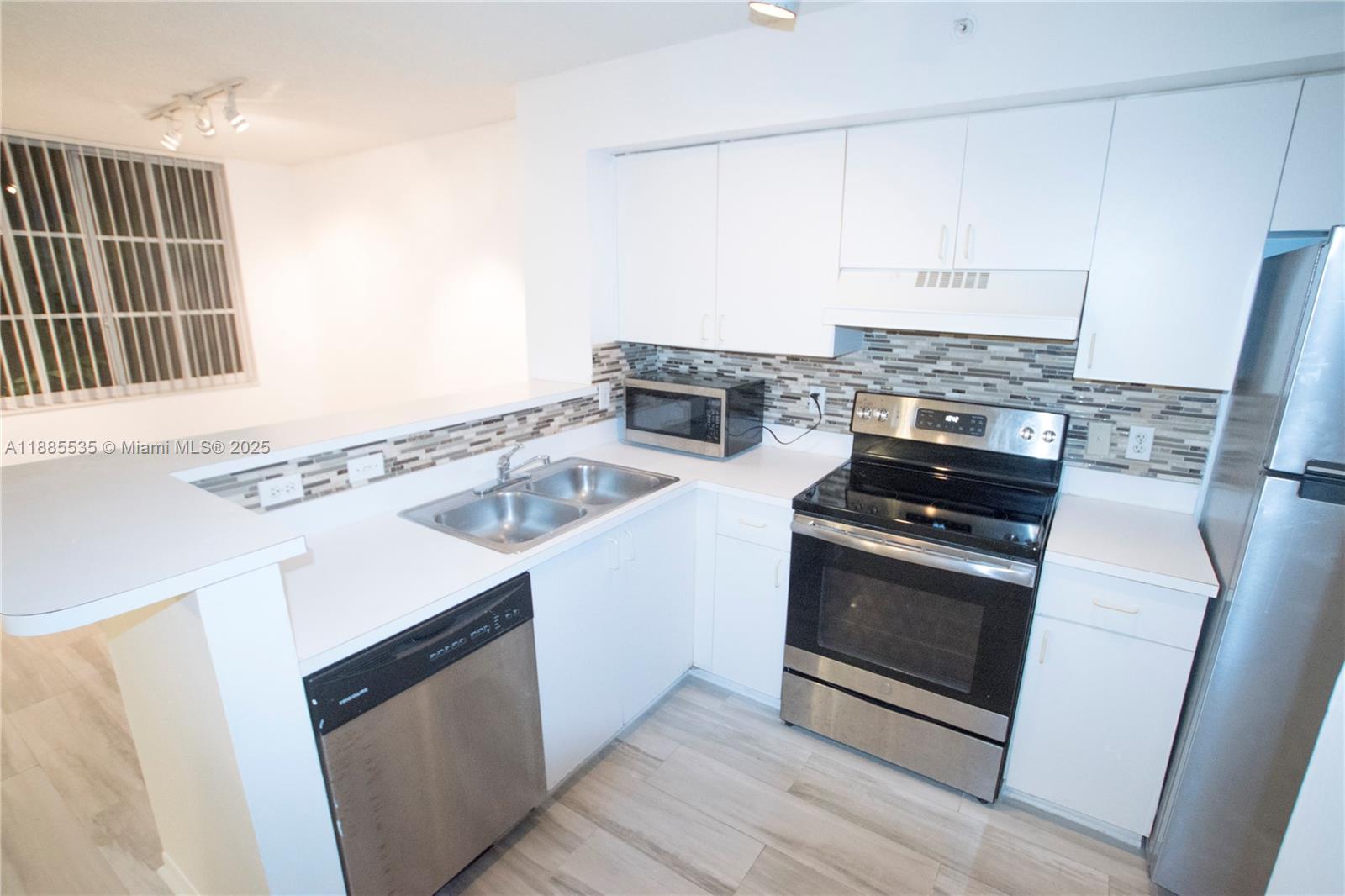 a kitchen with granite countertop a sink stove and refrigerator