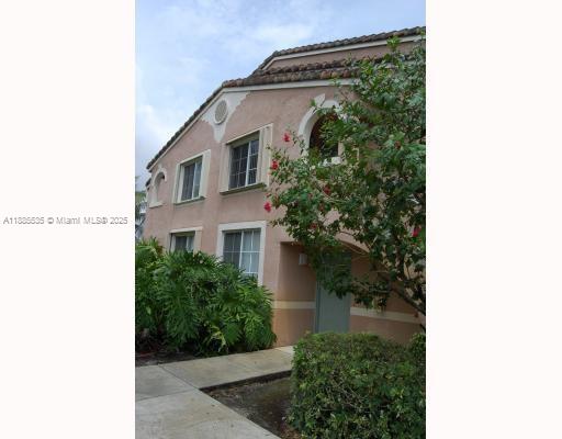 12130 St Andrews Place, Unit 101 Miramar, FL 33025 - Photo 12 of 13 a front view of a house with plants