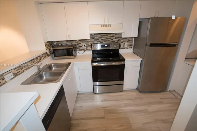 a kitchen with a sink stove and refrigerator