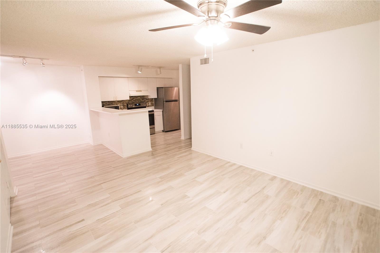 12130 St Andrews Place, Unit 101 Miramar, FL 33025 - Photo 6 of 13 a kitchen with granite countertop white cabinets and white appliances