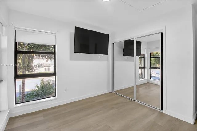 a view of an empty room with window and cabinet