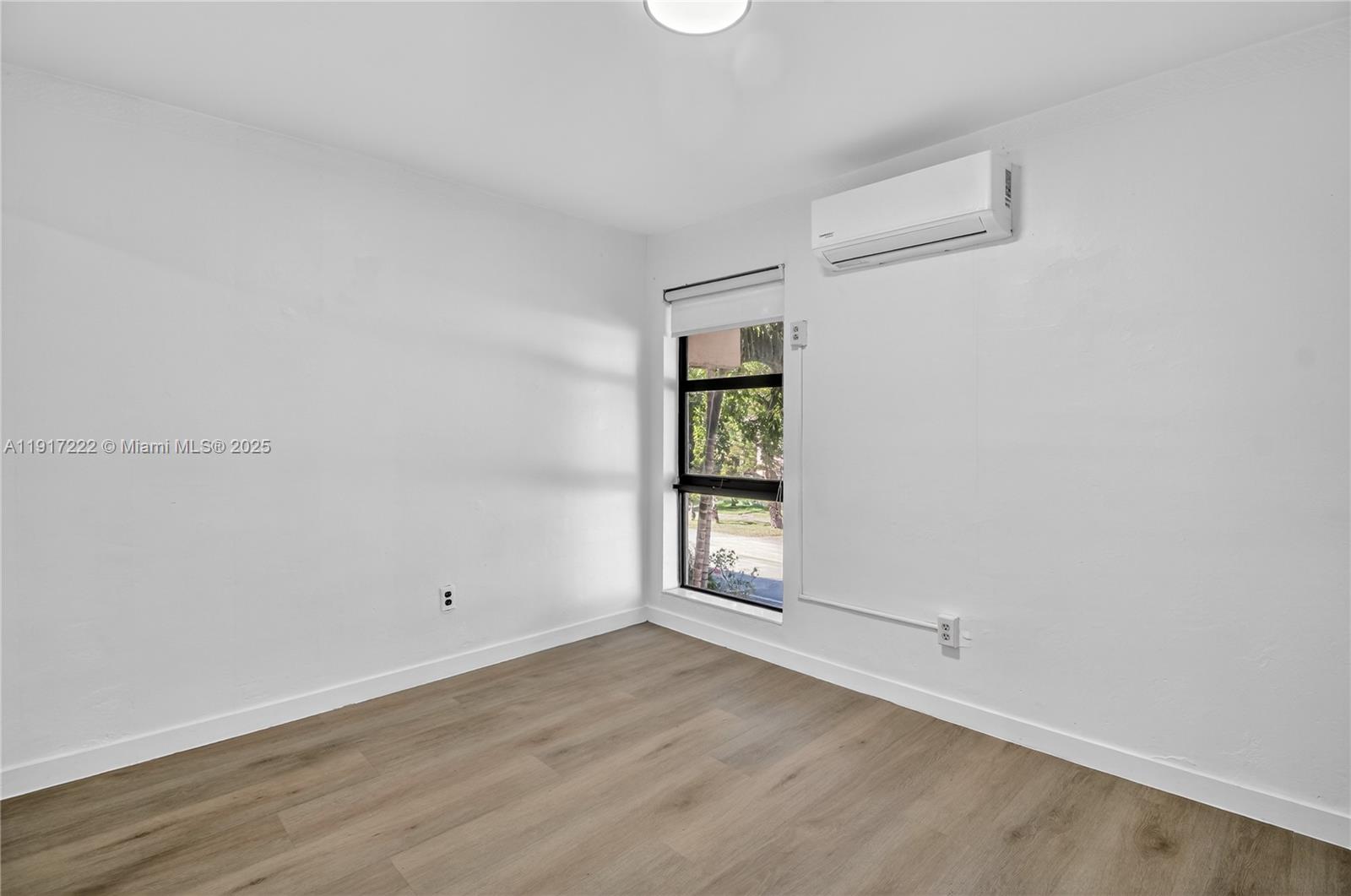 1600 South Le Jeune Road, Unit 7 Coral Gables, FL 33134 - Photo 15 of 20 an empty room with wooden floor and window