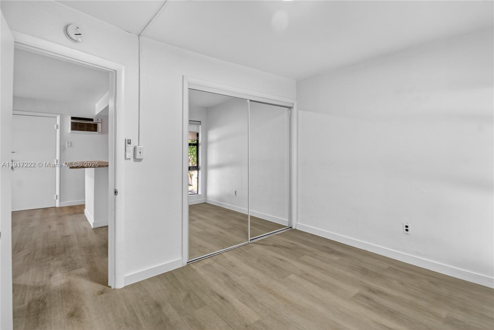 1600 South Le Jeune Road, Unit 7 Coral Gables, FL 33134 - Photo 16 of 20 an empty room with wooden floor and windows