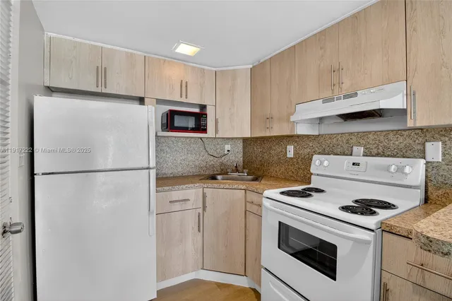 a kitchen with a stove a refrigerator and a sink