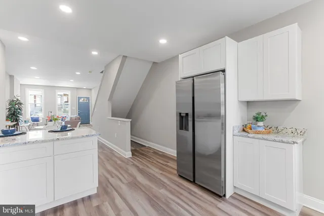a kitchen with white cabinets and stainless steel appliances