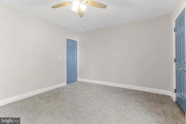 an empty room with a chandelier fan
