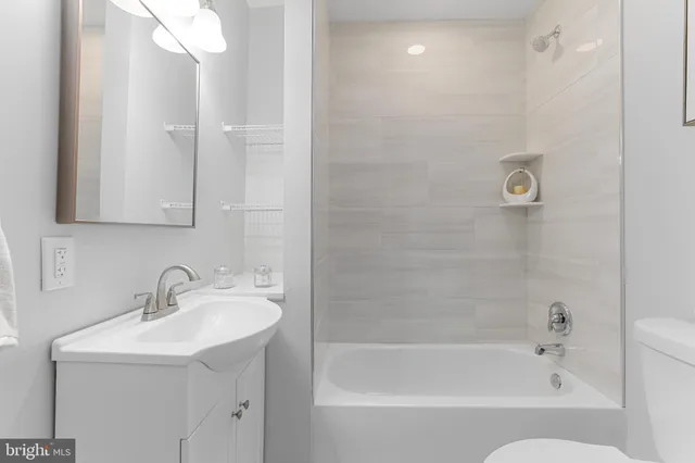 a bathroom with a bathtub shower sink and mirror