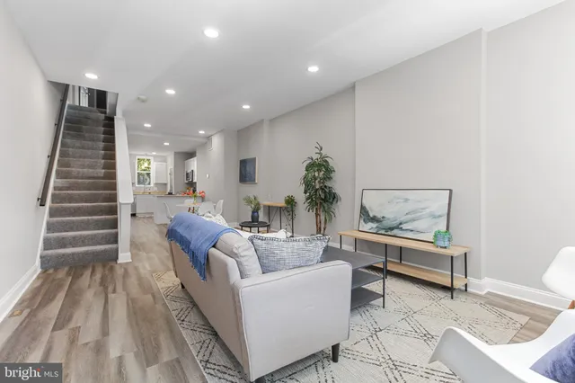 a living room with furniture and a wooden floor