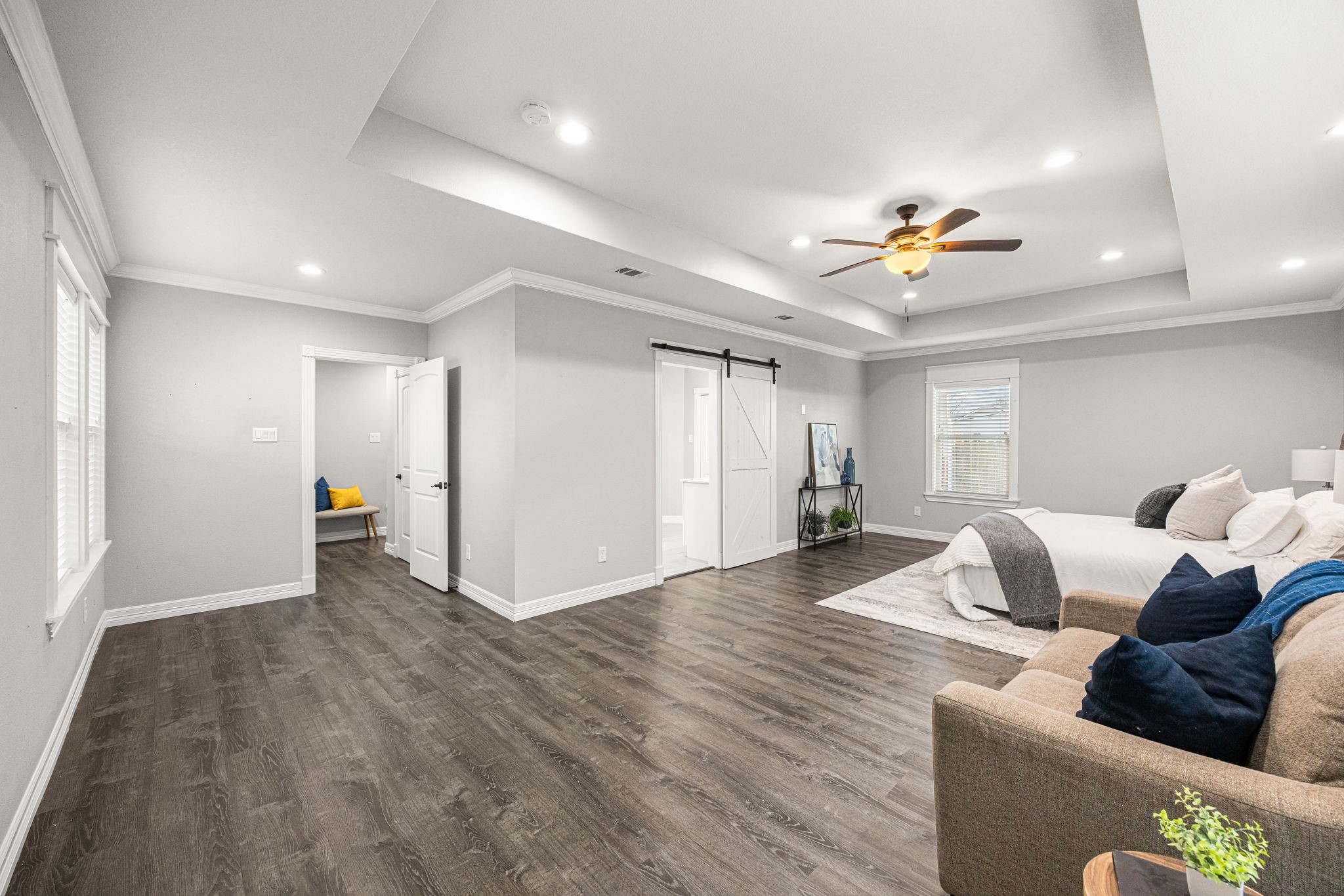 1405 Walton Street Houston, TX 77009 - Photo 15 of 28 Oversized primary suite with tray ceilings and sliding barn doors opening to the en-suite bath, blending space, style, and functionality.