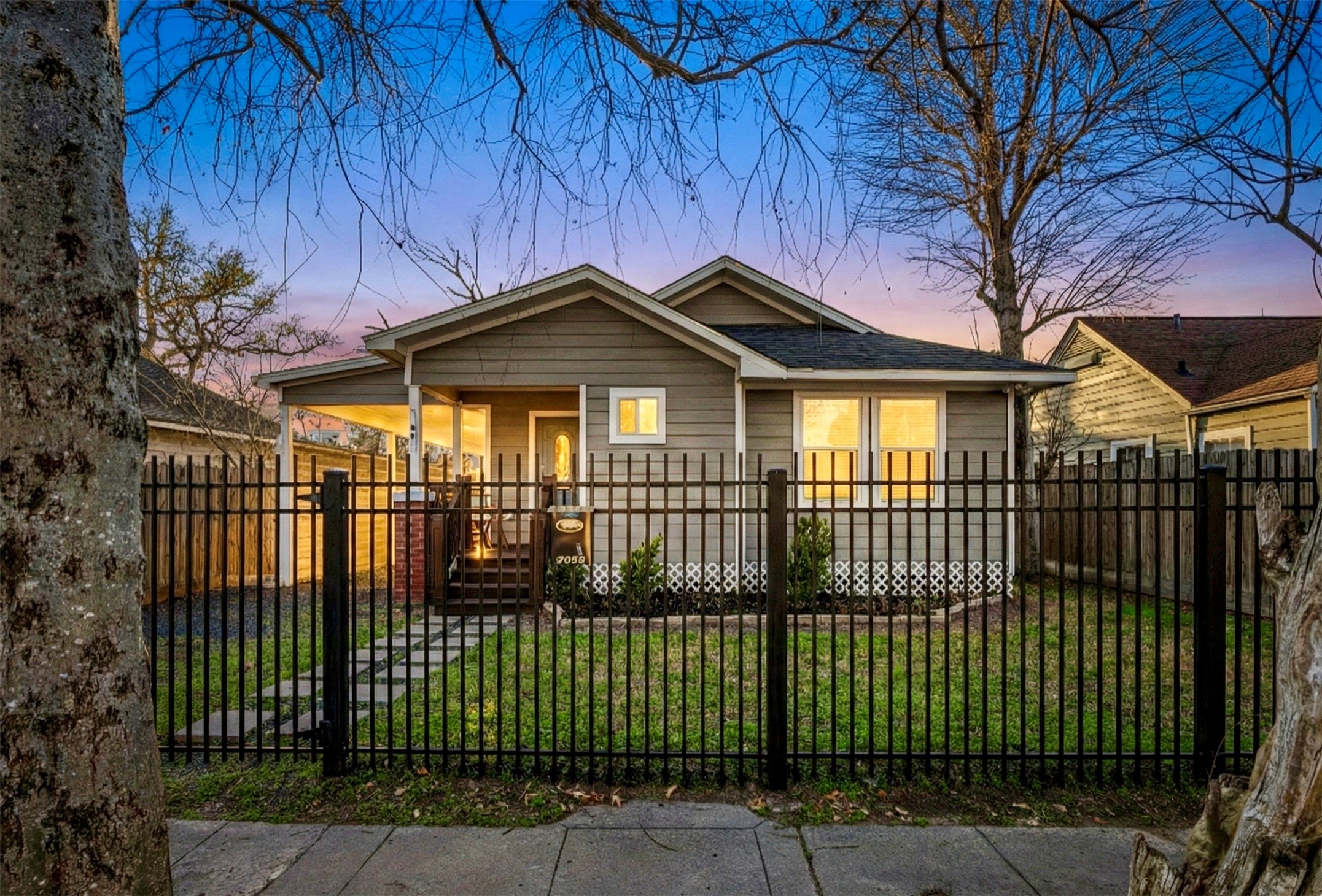 1405 Walton Street Houston, TX 77009 - Photo 2 of 28 Inviting front exterior featuring a covered porch, fully fenced front yard, and charming architectural details that create standout curb appeal.