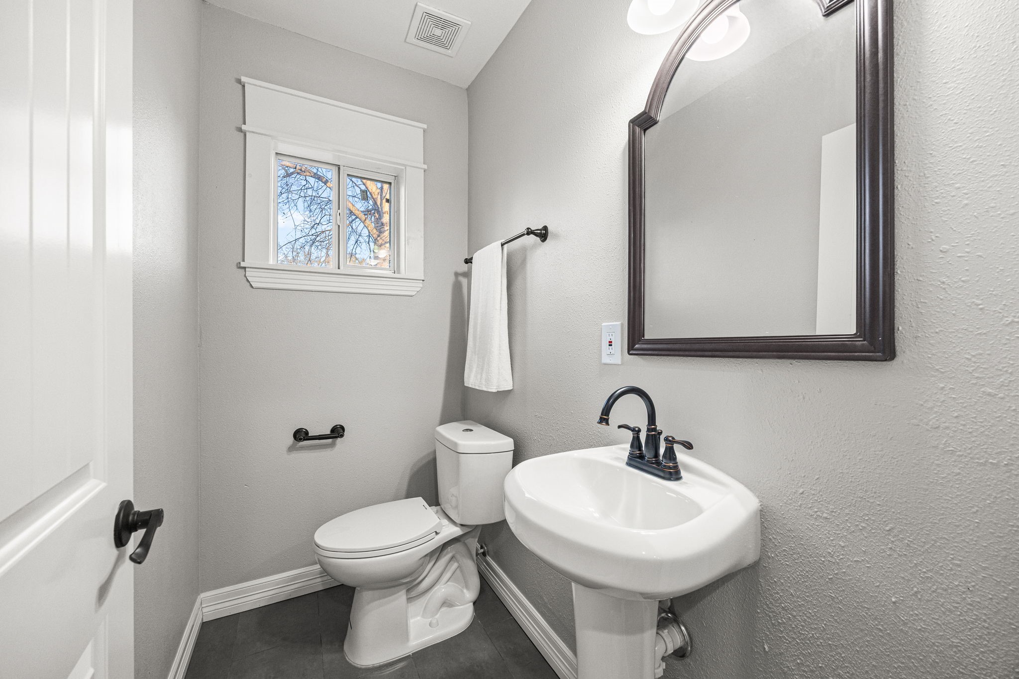 1405 Walton Street Houston, TX 77009 - Photo 23 of 28 Convenient guest half bath off the living room featuring pedestal sink, updated fixtures, and natural light for a clean, bright feel.