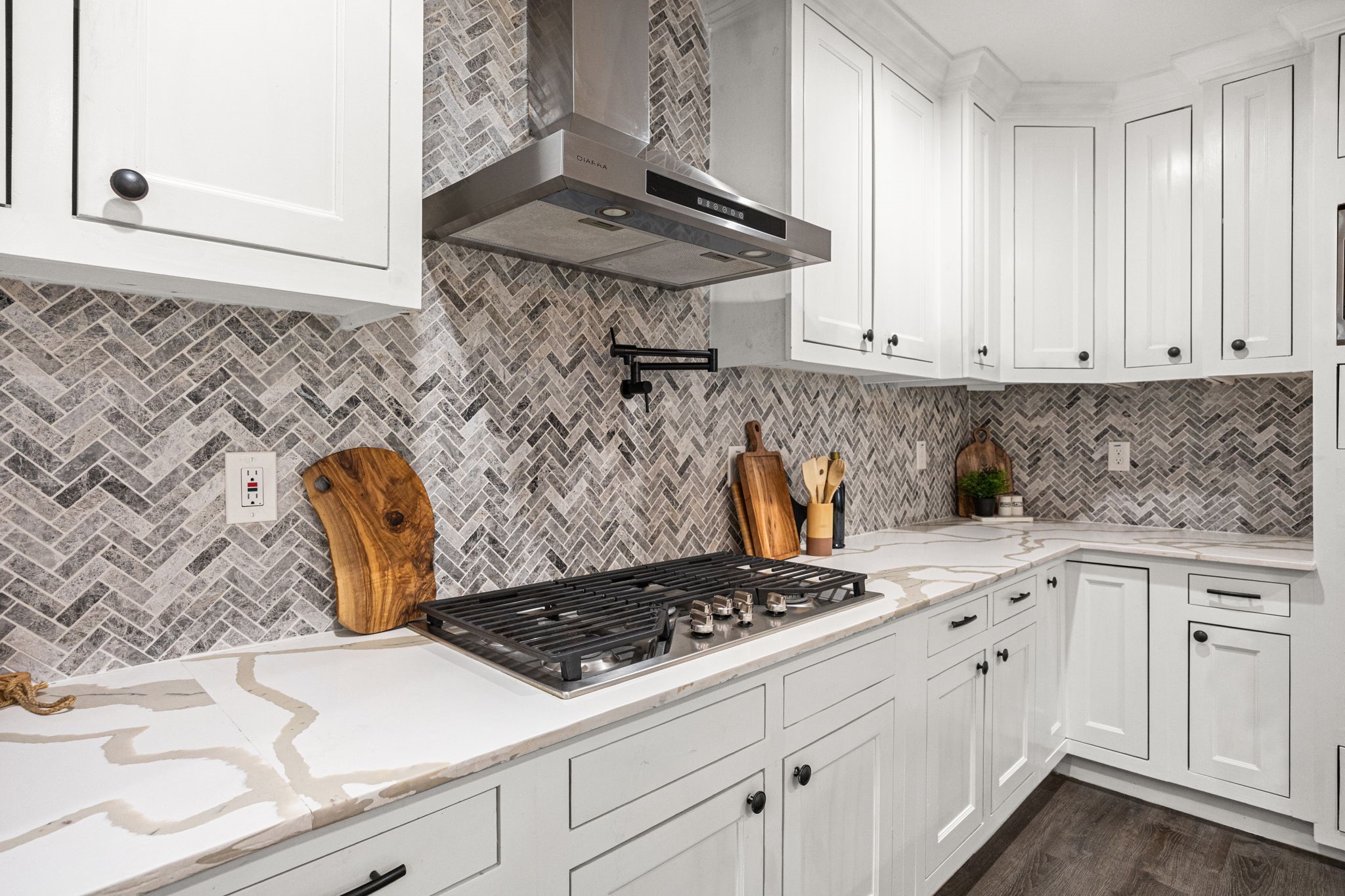 1405 Walton Street Houston, TX 77009 - Photo 7 of 28 Chef-inspired cooking space with gas cooktop, sleek vent hood, and eye-catching backsplash that adds texture and dimension.