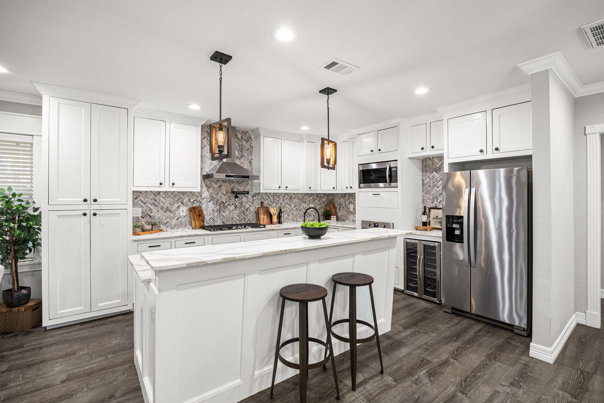 1405 Walton Street Houston, TX 77009 - Photo 10 of 28 Stunning kitchen featuring custom white cabinetry, quartz countertops, and statement herringbone backsplash for a sophisticated finish.